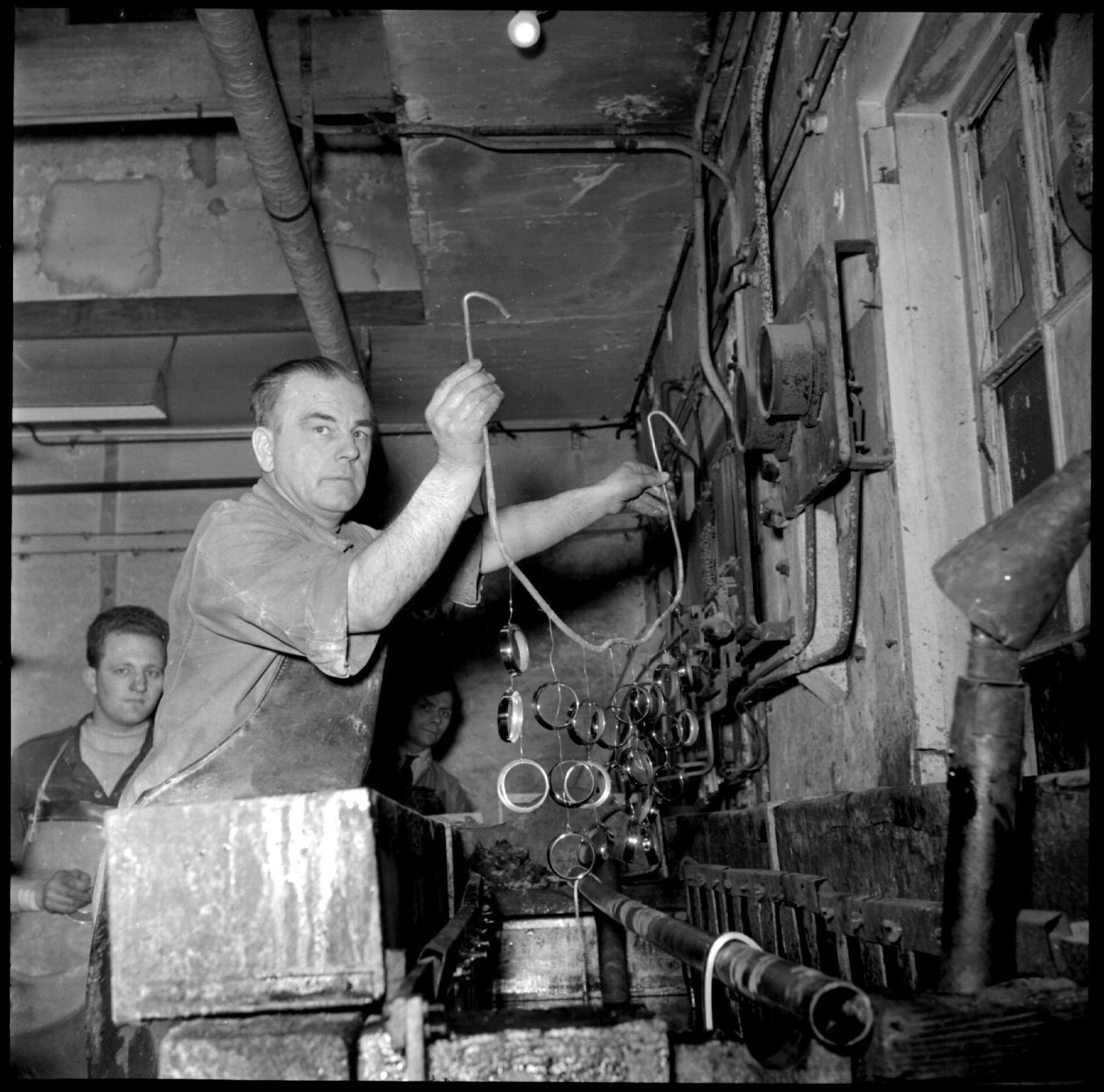 A metal plater at work and a young man watching, Amsterdam 1952